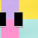 deux smartphones éteints sur fond jaune et violet